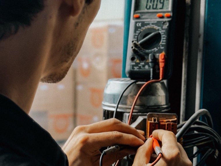 Electrician testing generator connections with a multimeter