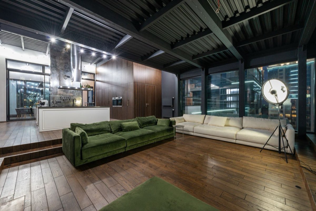 Modern open-plan living space lit by warm architectural lighting at night